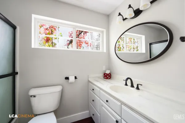 a bathroom with a toilet a sink and a mirror