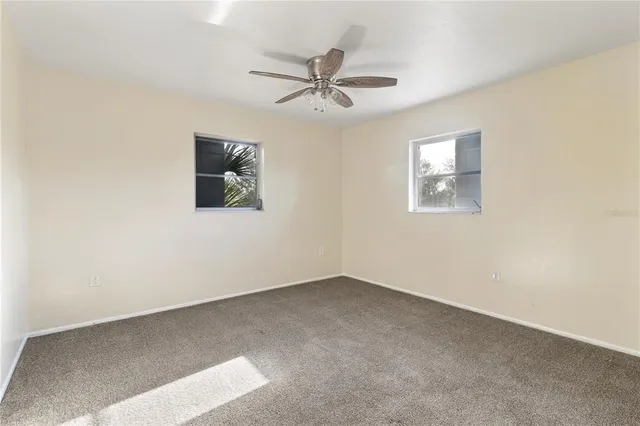 an empty room with a window and a fan