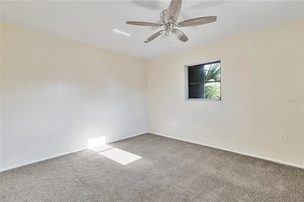 an empty room with a fan and a window