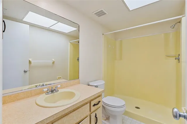 a bathroom with a granite countertop sink toilet and a mirror