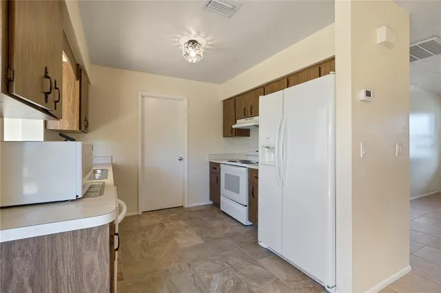 a kitchen with a refrigerator a stove top oven and a sink