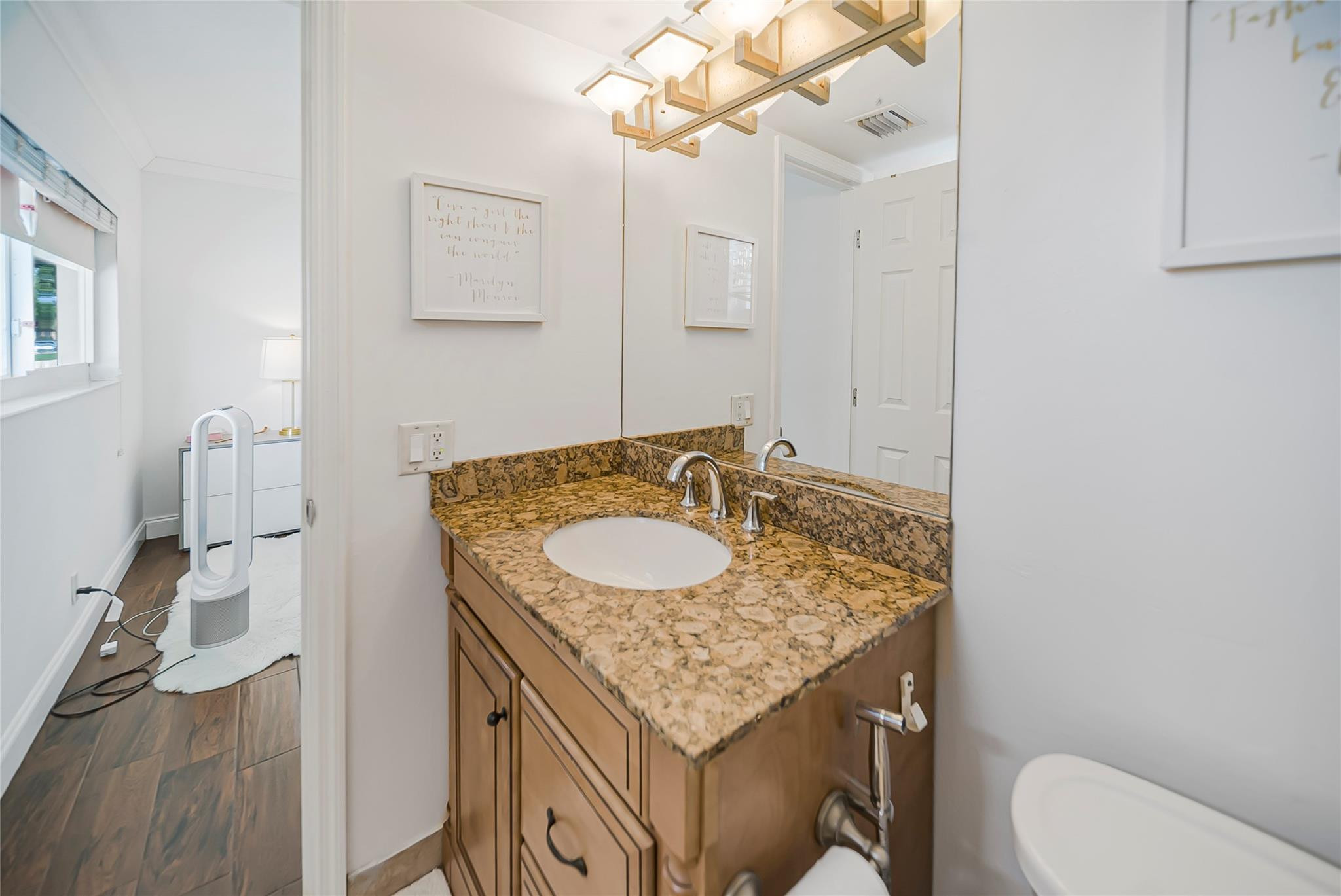 Undisclosed Address Deerfield Beach, FL 33441 - Photo 23 of 26 a bathroom with a granite countertop sink a toilet and a mirror