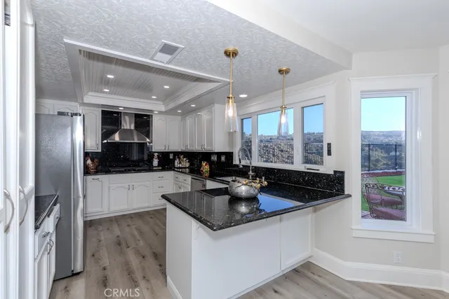 a kitchen with stainless steel appliances granite countertop a sink refrigerator and cabinets