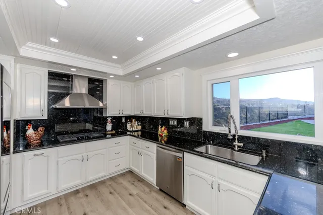 a kitchen with granite countertop a sink a counter space cabinets and stainless steel appliances