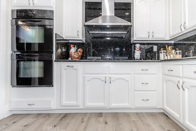 a kitchen with white cabinets and appliances