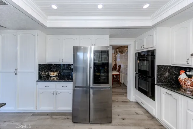 a kitchen with stainless steel appliances granite countertop a refrigerator and a stove top oven