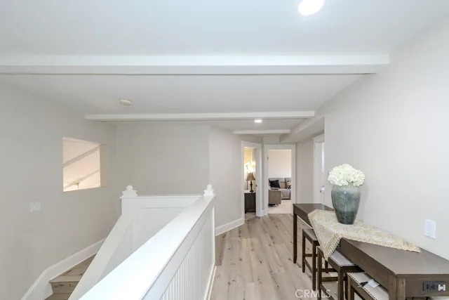 a view of a hallway with furniture and wooden floor