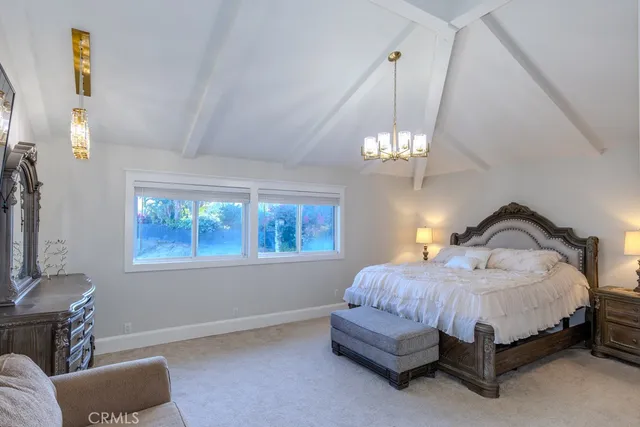 a spacious bedroom with a bed mirror and couch