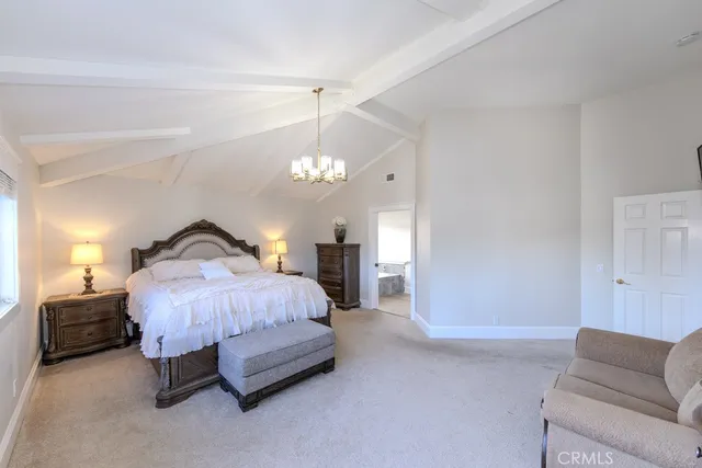 a spacious bedroom with a bed couch tv and a window