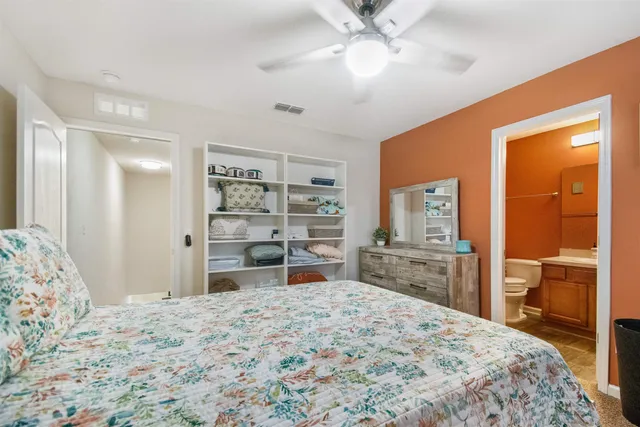 a bedroom with a large bed and a flat tv screen on dresser