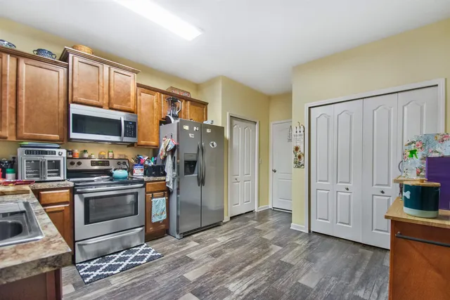 a kitchen with stainless steel appliances granite countertop a refrigerator stove and sink