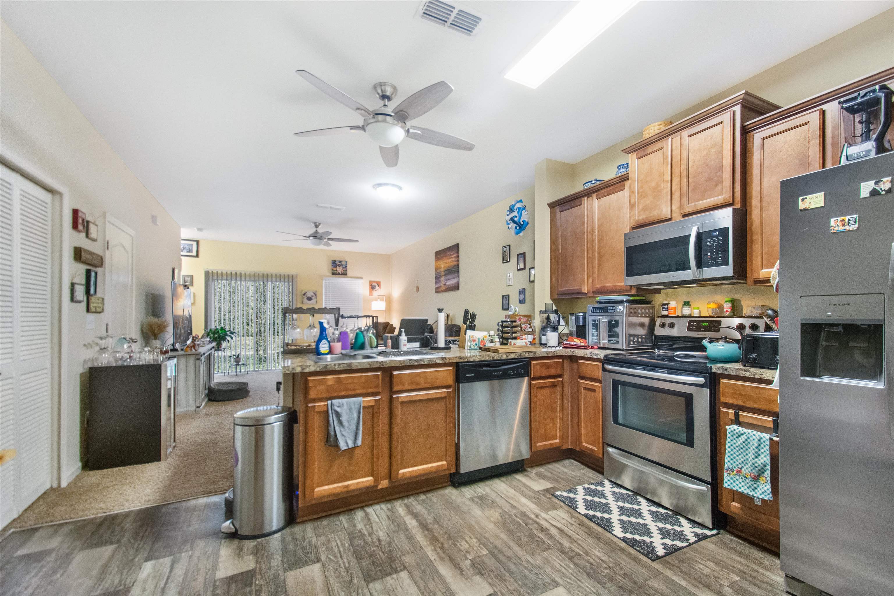 39 Whitland Way St. Augustine, FL 32086 - Photo 6 of 29 a kitchen with stainless steel appliances granite countertop a stove top oven a sink dishwasher a dining table and chairs with wooden floor