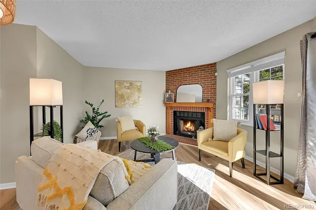 a living room with furniture a fireplace and a potted plant
