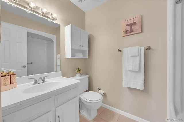 a bathroom with a toilet sink vanity and mirror