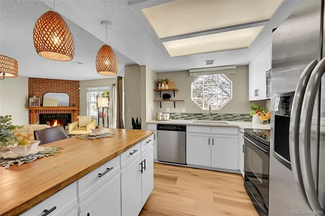 a kitchen with stainless steel appliances granite countertop a sink and a refrigerator