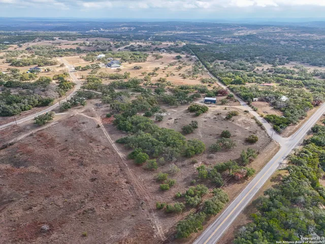 a view of a dry yard with wooden floor and fence