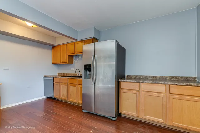 a kitchen with stainless steel appliances granite countertop a refrigerator and a stove top oven
