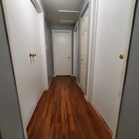 a view of a hallway with wooden floor and staircase