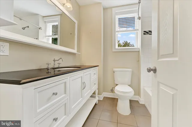 a bathroom with a sink a toilet and a mirror