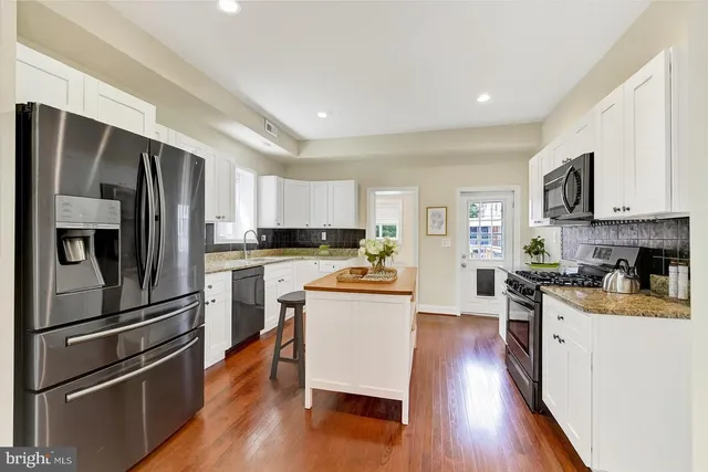 a kitchen with a refrigerator stove and wooden cabinets