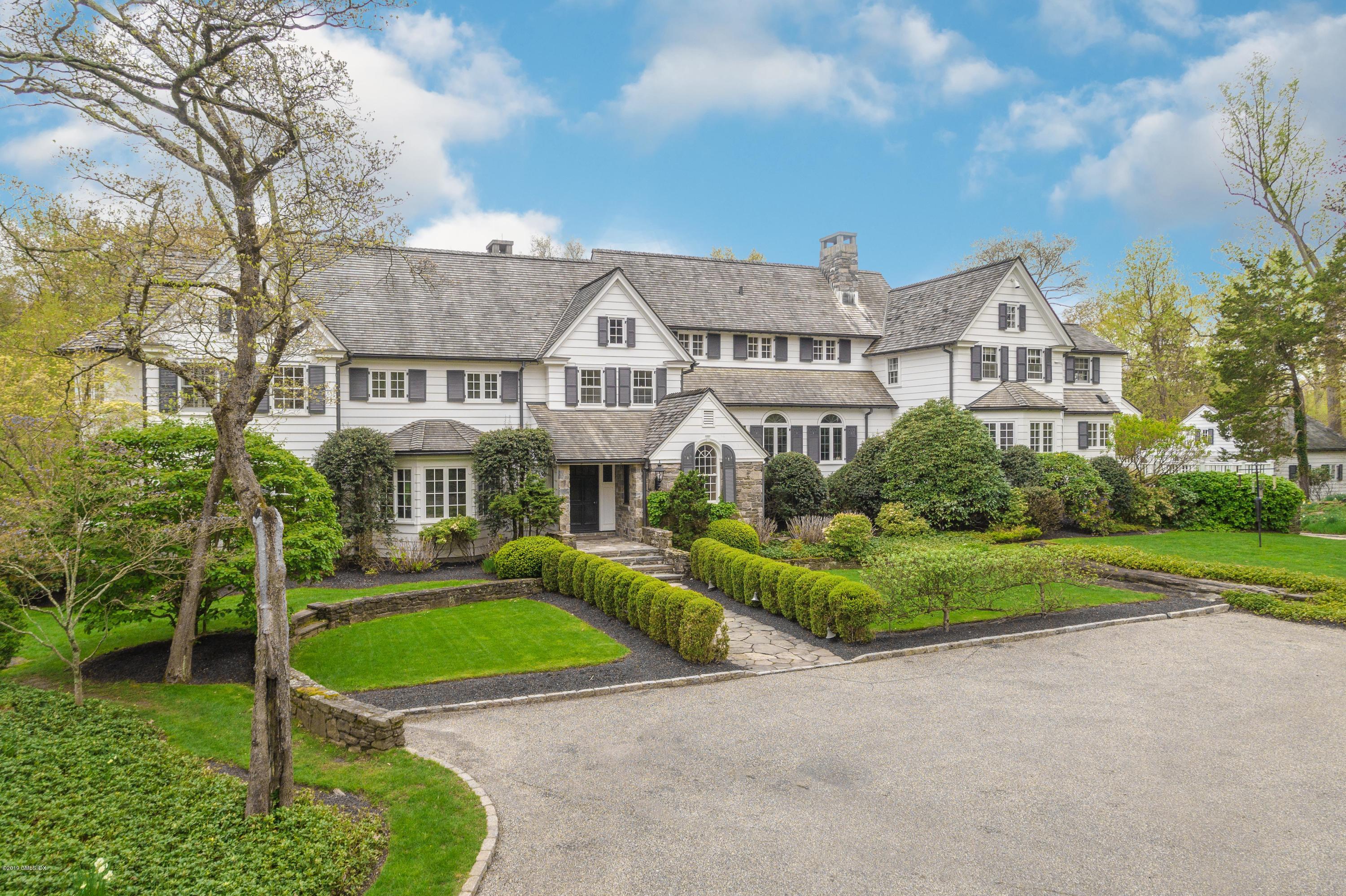 a front view of a house with a yard and potted plants