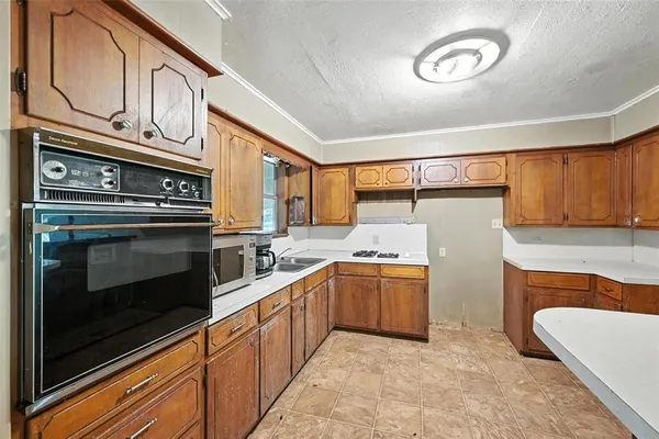 a kitchen with stainless steel appliances granite countertop a sink stove and cabinets