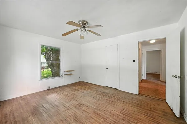 a view of room with window ceiling fan and hardwood floor