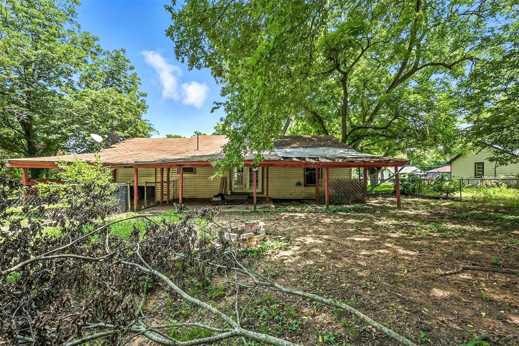 414 South Broadway Street Bells, TX 75414 - Photo 25 of 29 a backyard of a house with table and chairs under an umbrella