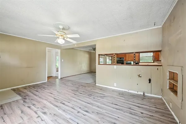 a view of a room with wooden floor and ceiling fan