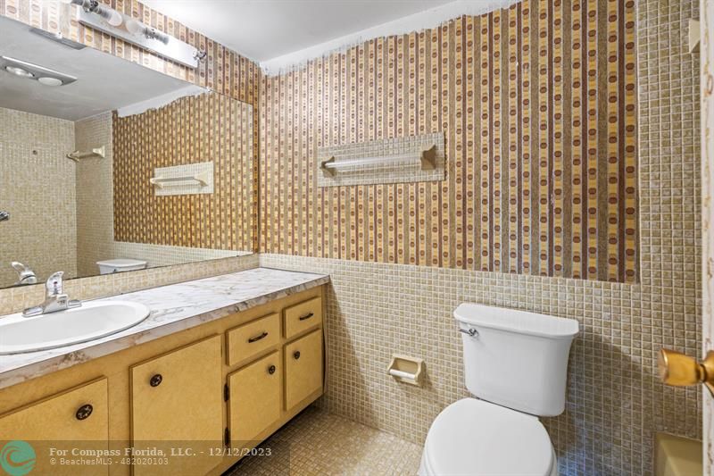 4750 Northwest 22nd Court, Unit 417 Lauderhill, FL 33313 - Photo 13 of 24 a bathroom with a granite countertop toilet sink and mirror