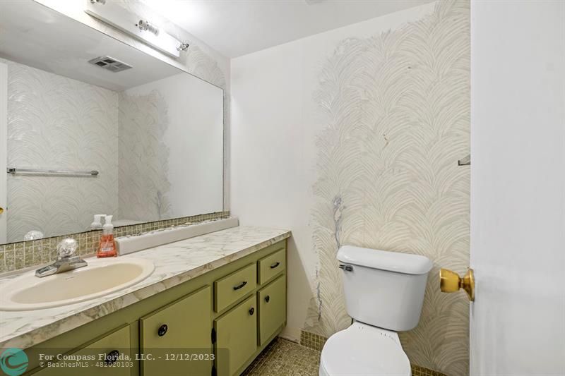 4750 Northwest 22nd Court, Unit 417 Lauderhill, FL 33313 - Photo 14 of 24 a bathroom with a granite countertop toilet sink and mirror
