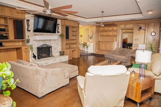 a living room with furniture a flat screen tv and a fireplace