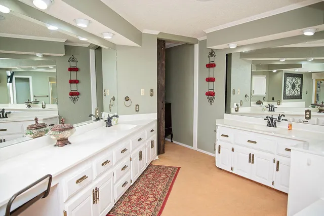 a spacious bathroom with double vanity and mirrors