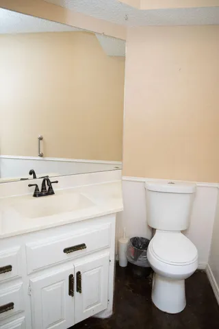 a bathroom with a sink a toilet and mirror