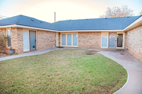 a front view of a house with a garden and yard