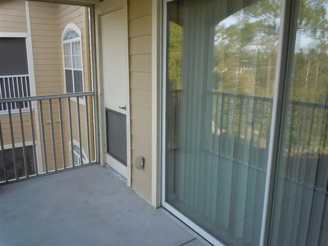 a living room with furniture and a view of kitchen