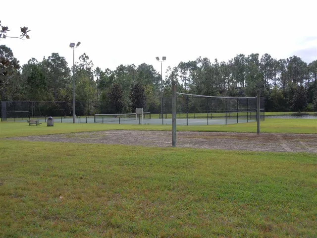 a view of a fountain in a yard with palm trees