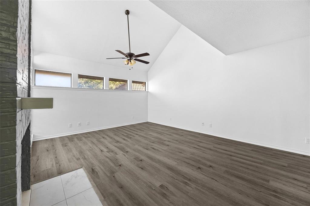 18240 Midway Road, Unit 402 Dallas, TX 75287 - Photo 29 of 29 Spacious room featuring vaulted ceilings, wood-finish flooring, and a contemporary ceiling fan