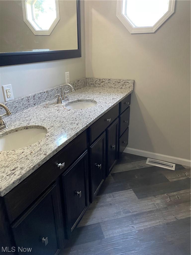 7114 Risden Road Vermilion, OH 44089 - Photo 34 of 35 Bathroom featuring dark hardwood flooring, double large vanity, and mirror