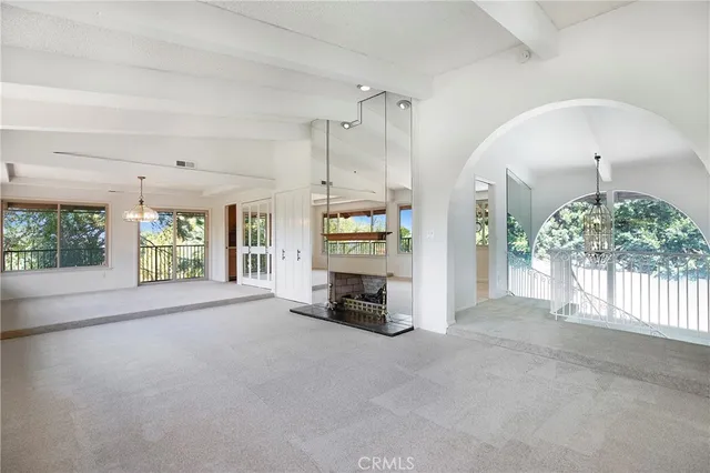 a view of an empty room with a fireplace and a window