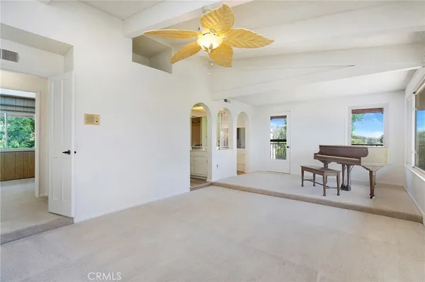 an empty room with windows and fireplace