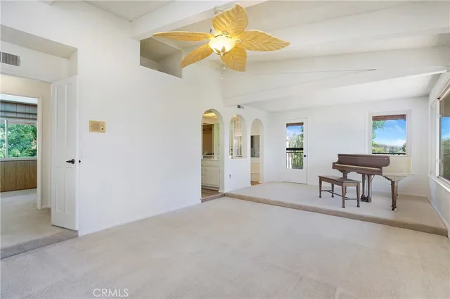 an empty room with windows and fireplace