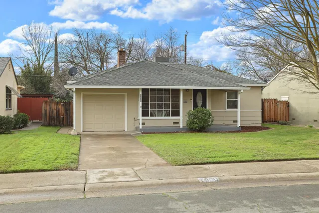 a front view of a house with a garden and yard