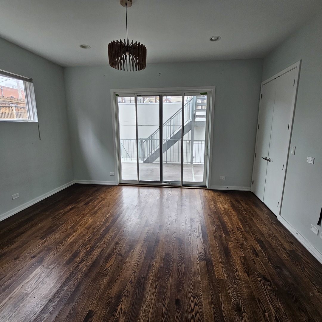 1013 North Honore Street, Unit 1 Chicago, IL 60622 - Photo 11 of 17 a view of an empty room with wooden floor and a window