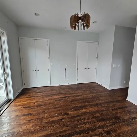 a view of empty room with wooden floor and window