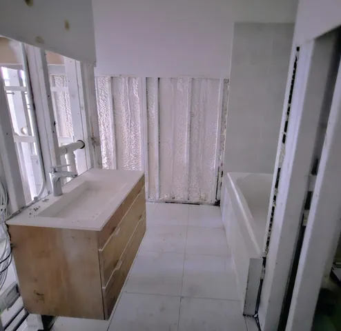 a bathroom with sink a window and a shower