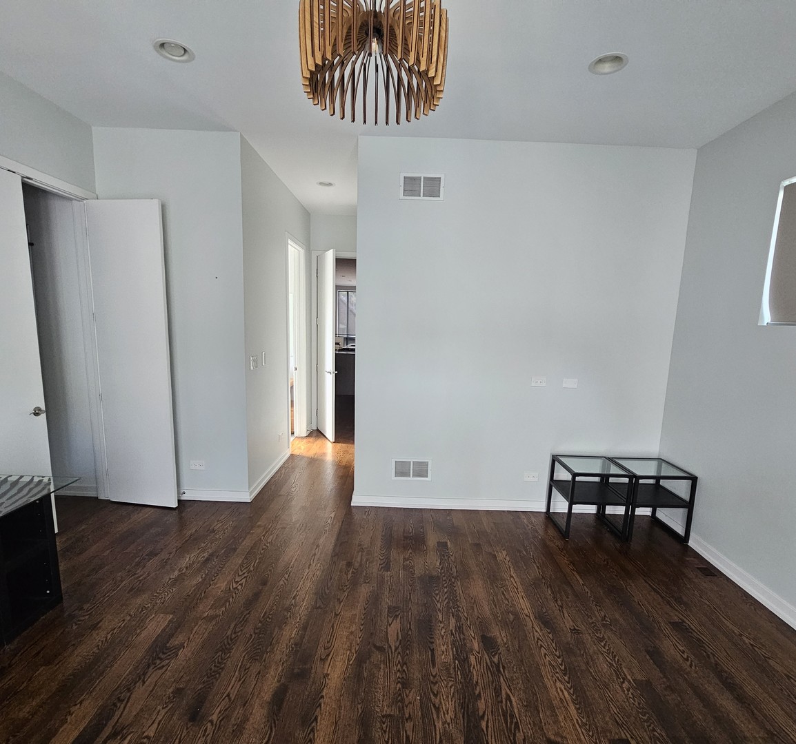 1013 North Honore Street, Unit 1 Chicago, IL 60622 - Photo 6 of 17 a view of a room with wooden floor and a cabinet
