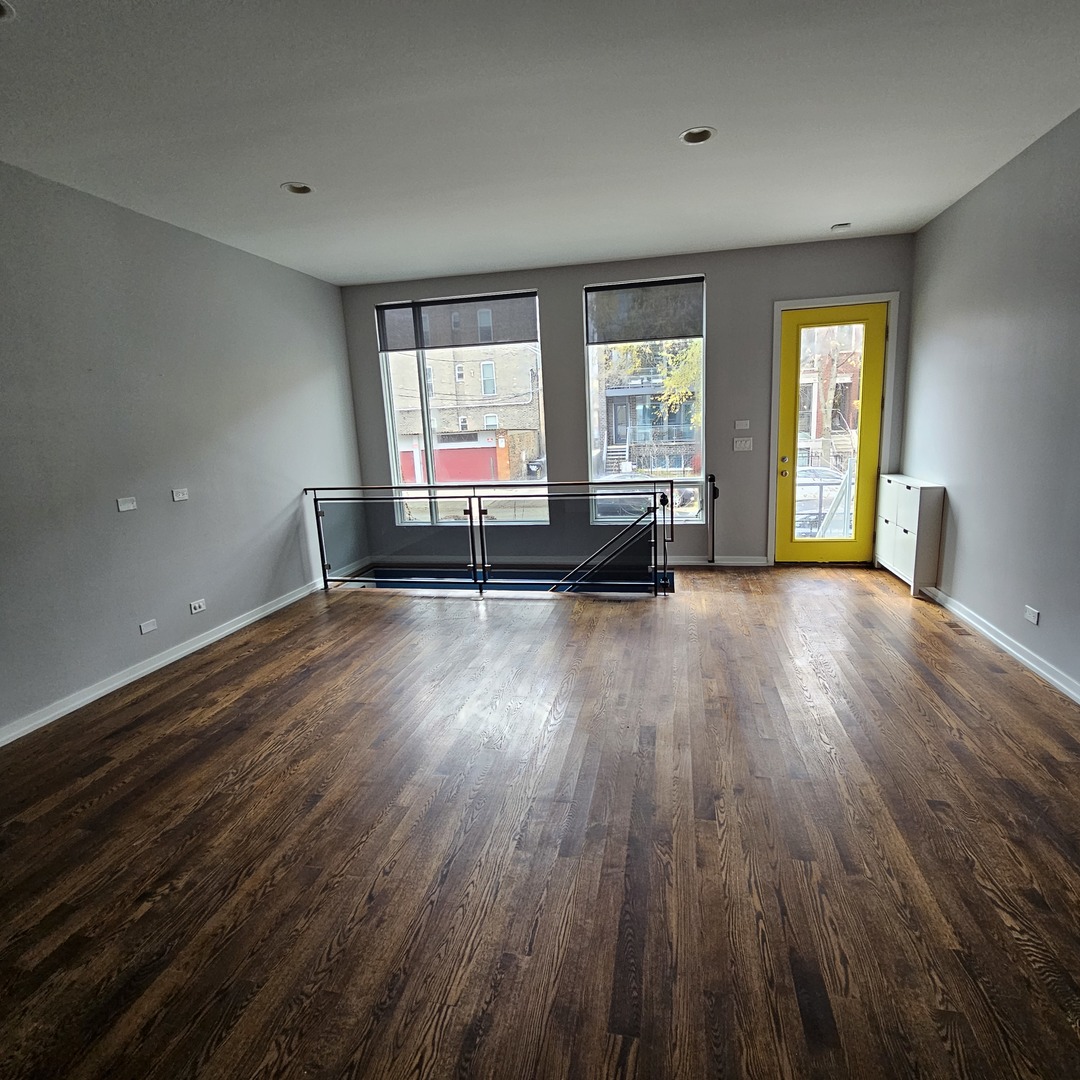 1013 North Honore Street, Unit 1 Chicago, IL 60622 - Photo 8 of 17 an empty room with wooden floor and windows