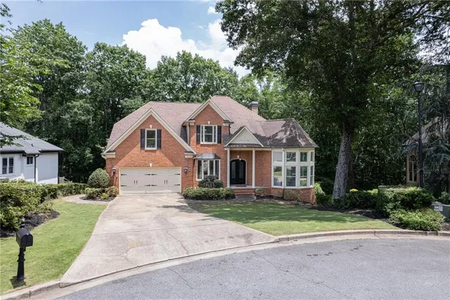 a front view of a house with a yard and trees