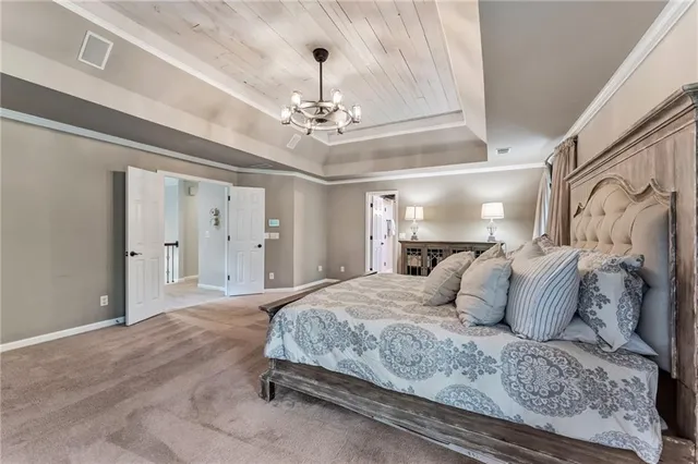 a bedroom with a large bed and a chandelier